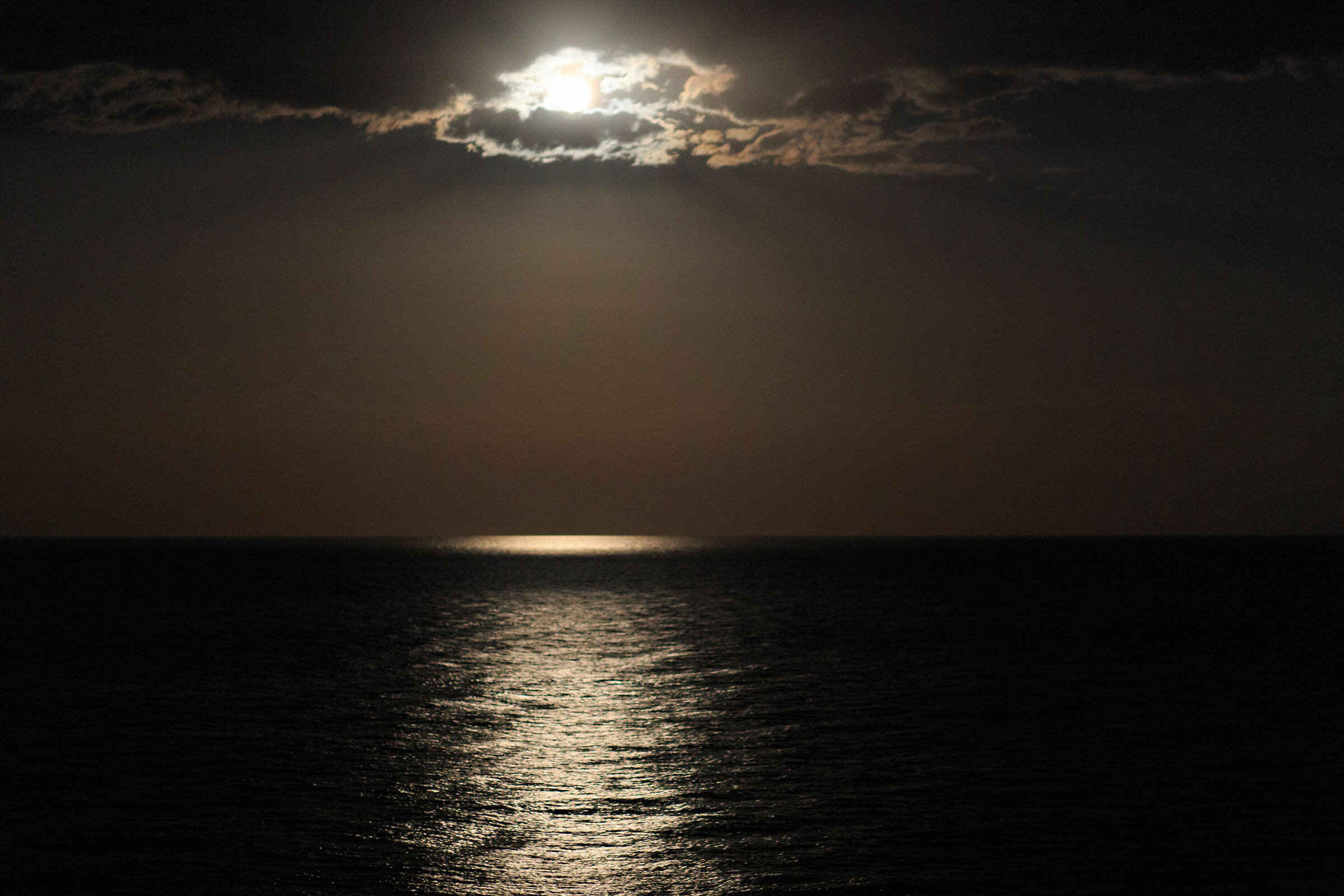 Luna sul mare dietro le nubi...
