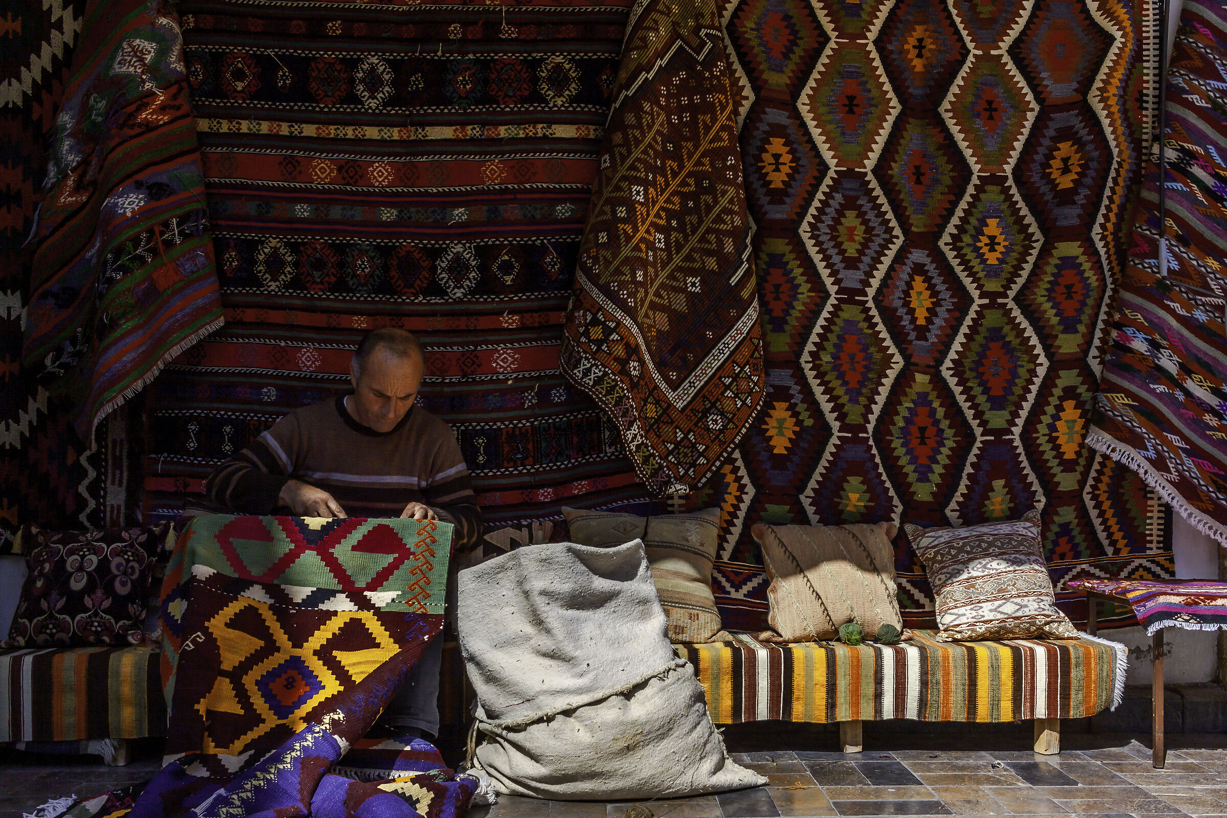 Un uomo che ripara il vecchio tappeto ad Antalya, in Turchia....