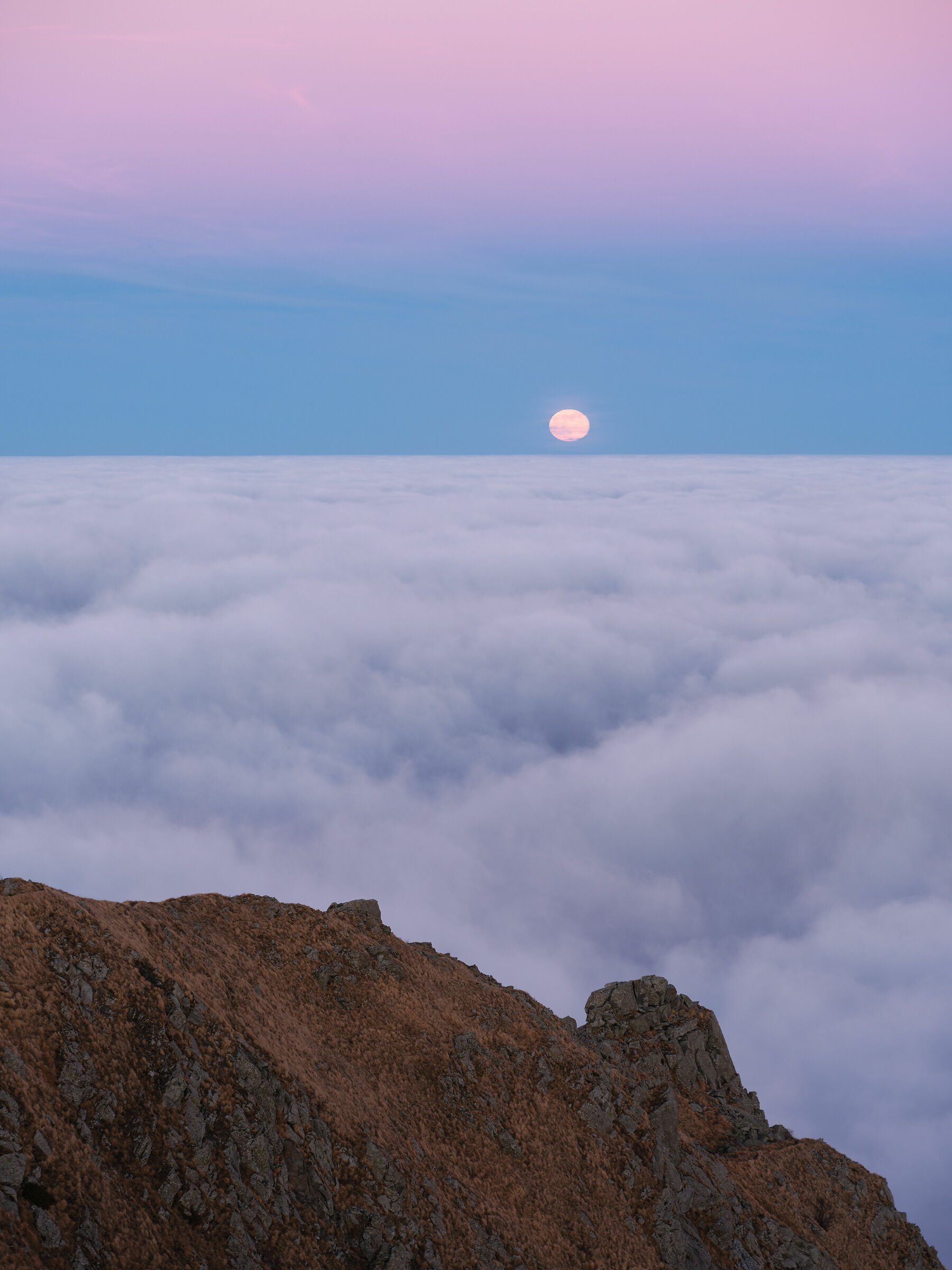 The moon rises above the clouds, from the top of Ventasso...